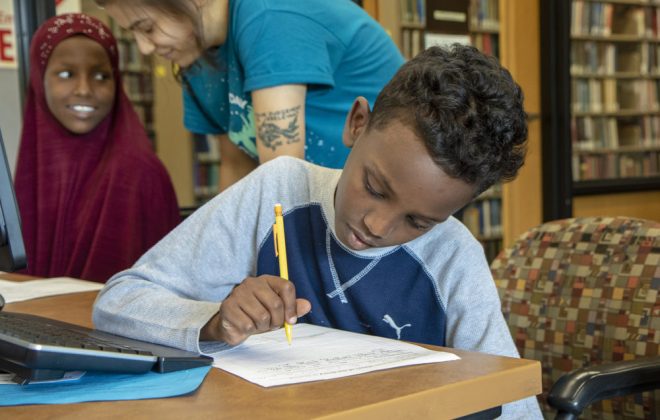 Student completing written assignment during the Summer Athletic and Immersive Learning program