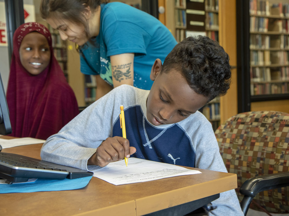 Student completing written assignment during the Summer Athletic and Immersive Learning program