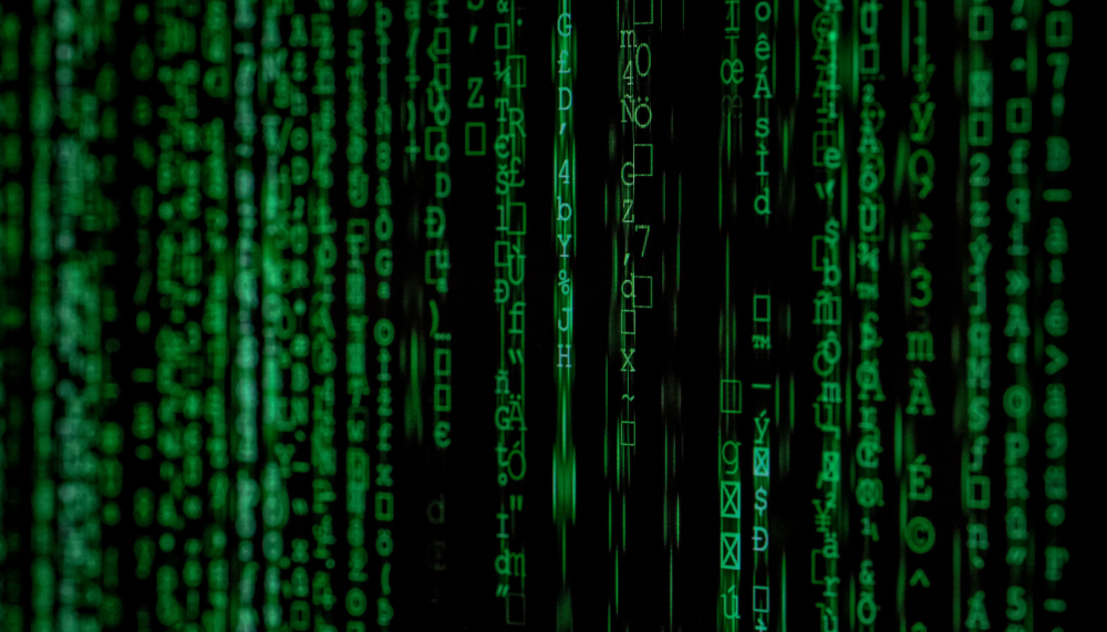 Image with green letters and numbers falling vertically over a black background.