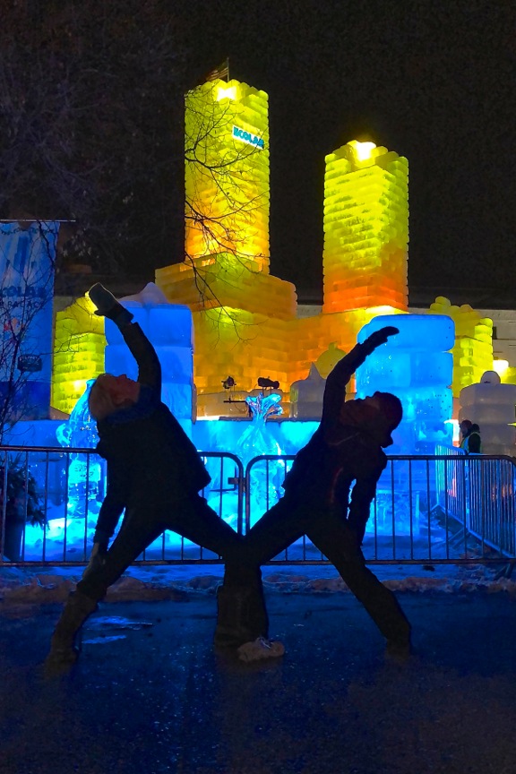 Two women practicing yoga outside in winter.