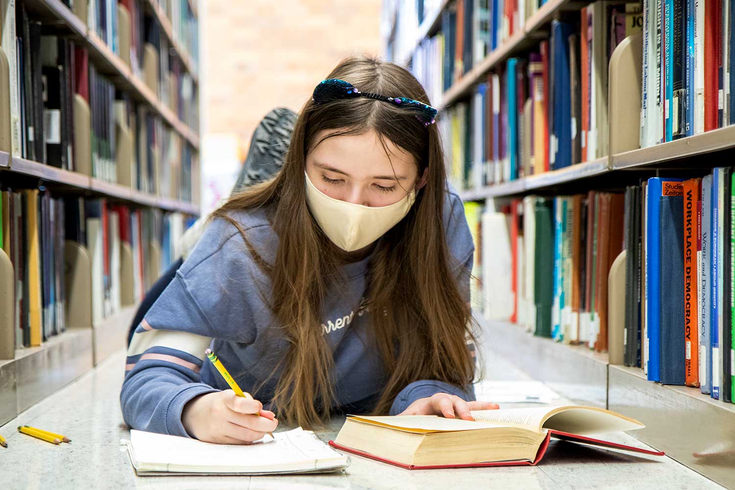 Student lying down in the stacks at Wilson Library.