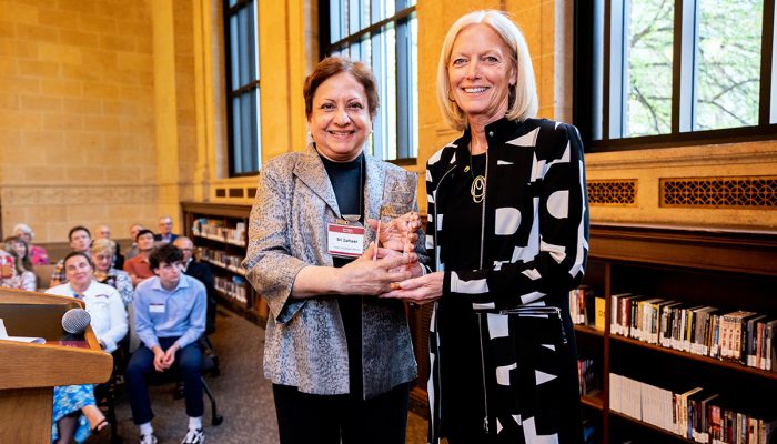 Woman holding glass award next to Sri Zaheer, Carlson School of Management Dean, at Founders Day 2023