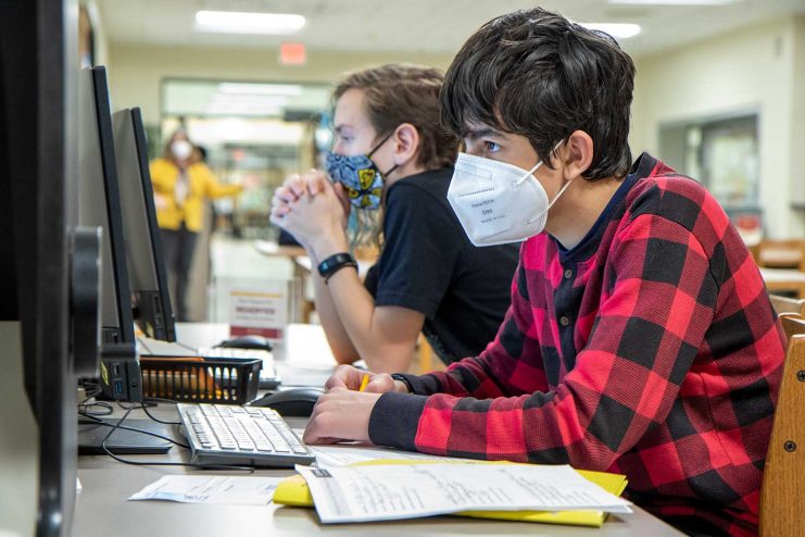 Two students on computers in Wilson Library.