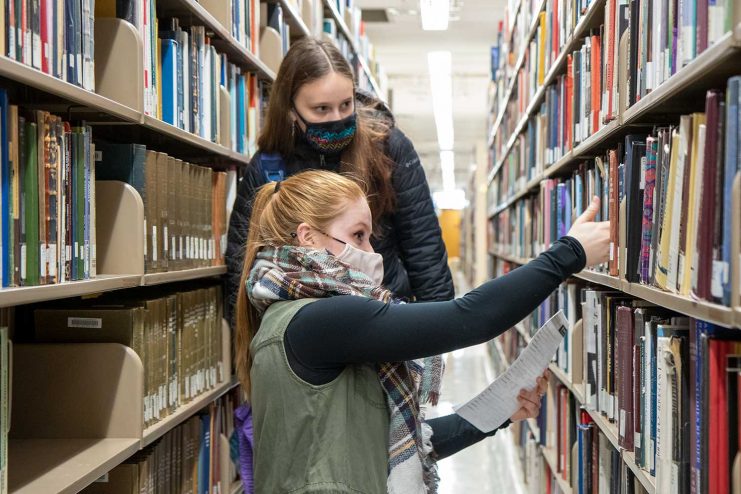Mom and child looking for books.