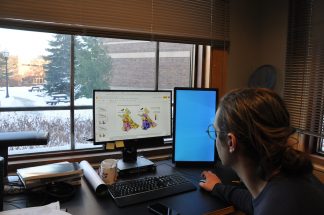 Researcher examining data on a computer, in a university office
