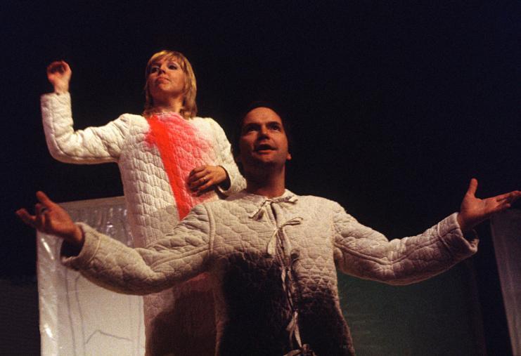 Performers in costume singing in Transformations
