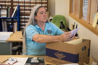 Lisa Vecoli looking through a box of materials