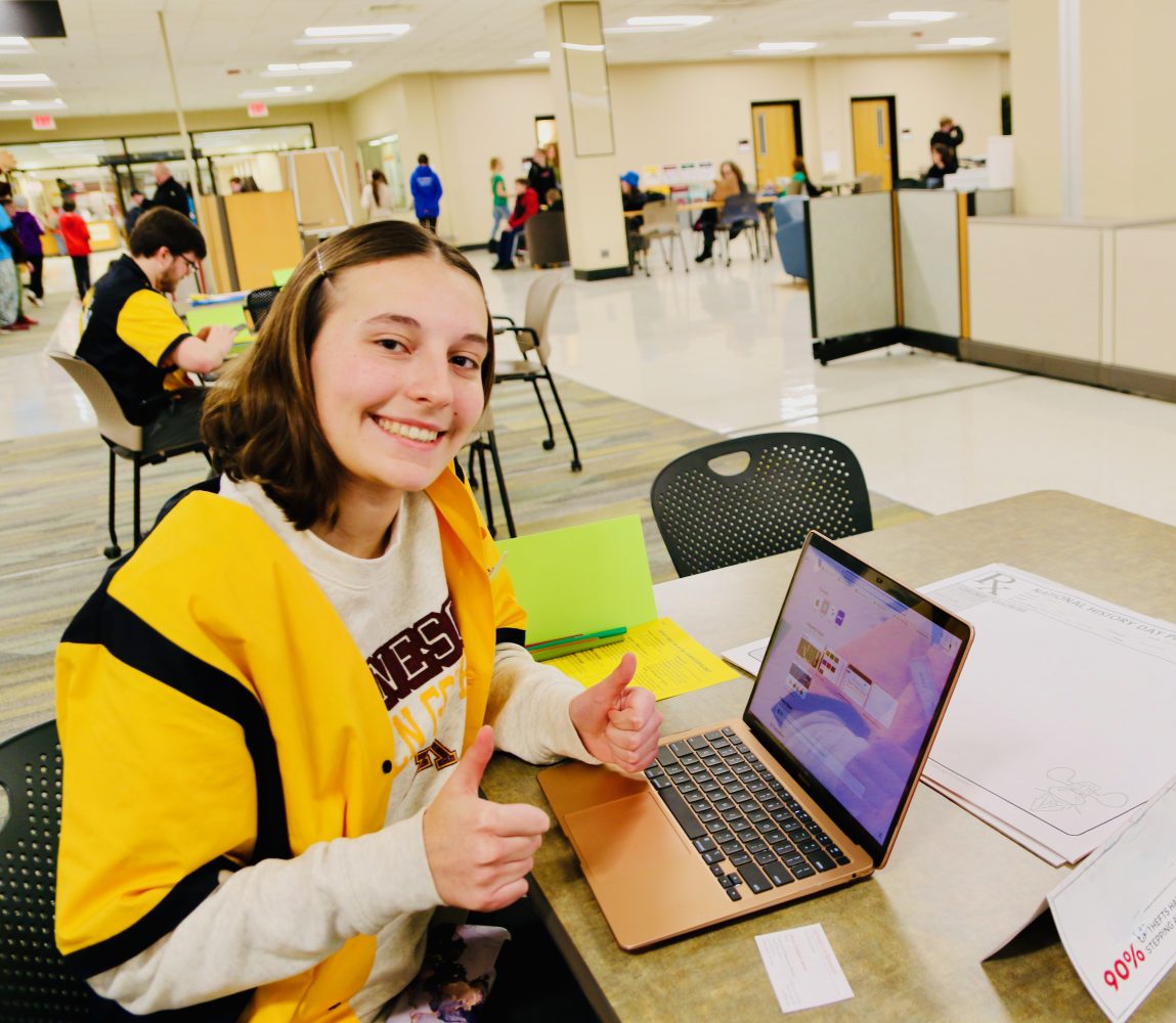 Student posing with thumbs up