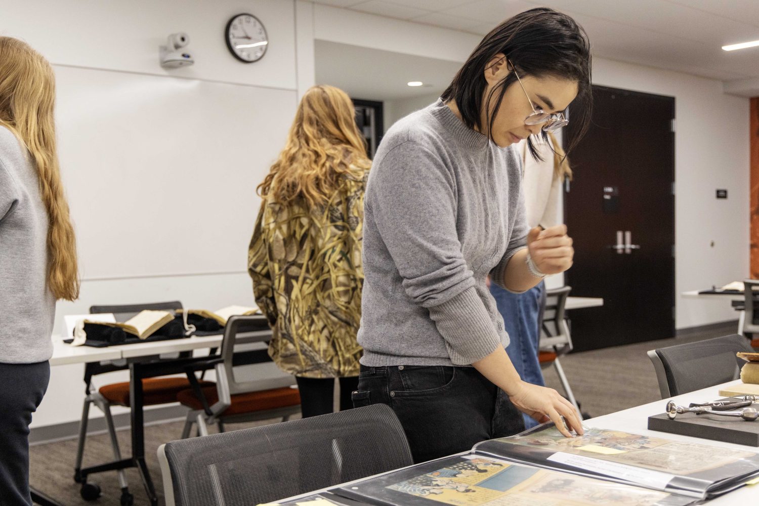 A student reads a rare book at the Wangensteen pop-up exhibit.