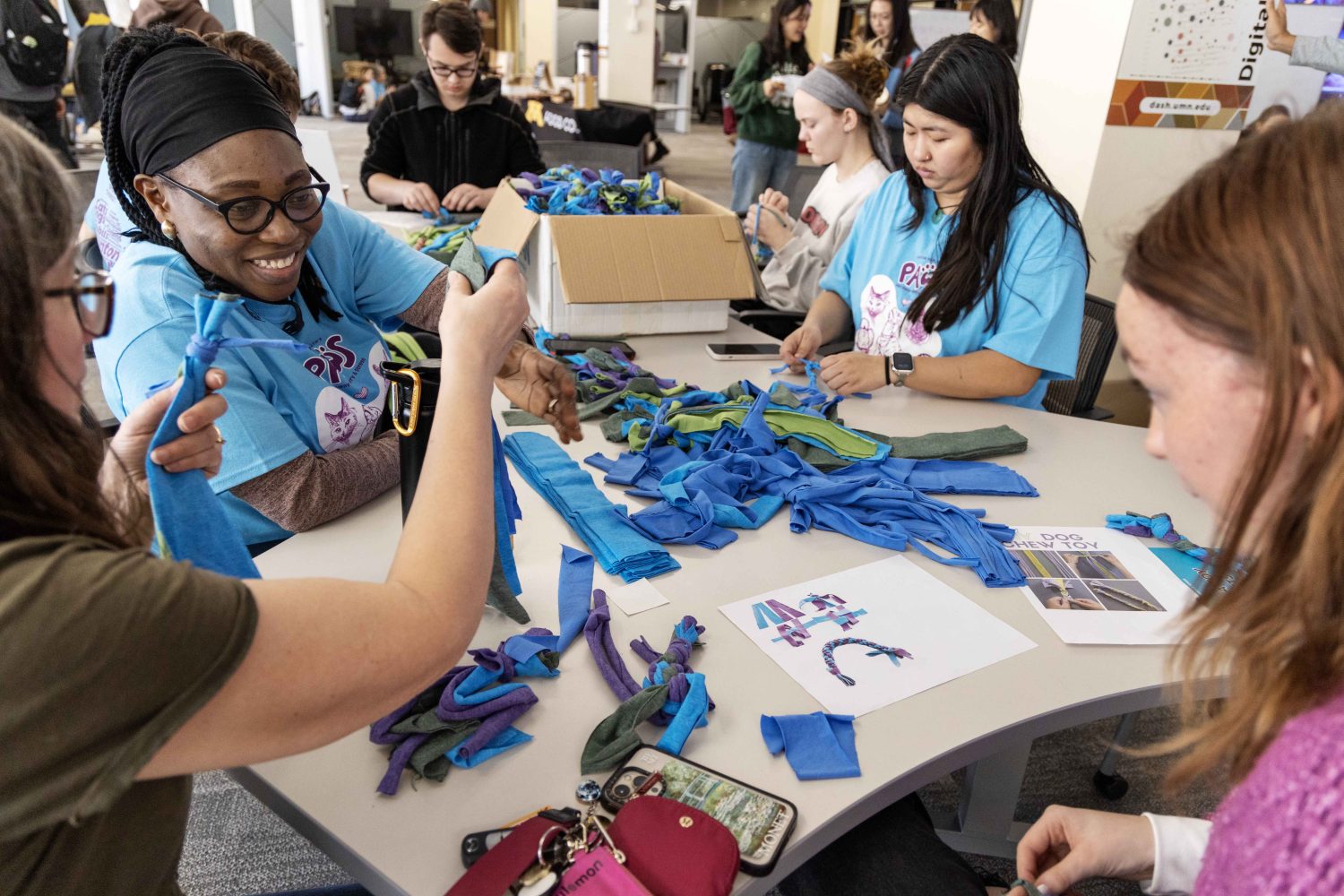 Attendees make dog toys out of strips of cloth at the PAWS 10th anniversary at Wilson Library on Thursday, Nov. 16, 2023. (Photo/Adria Carpenter)