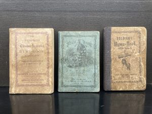 Image from the YMCA archives of three hymn books distributed to soldiers in the US Armed Forces