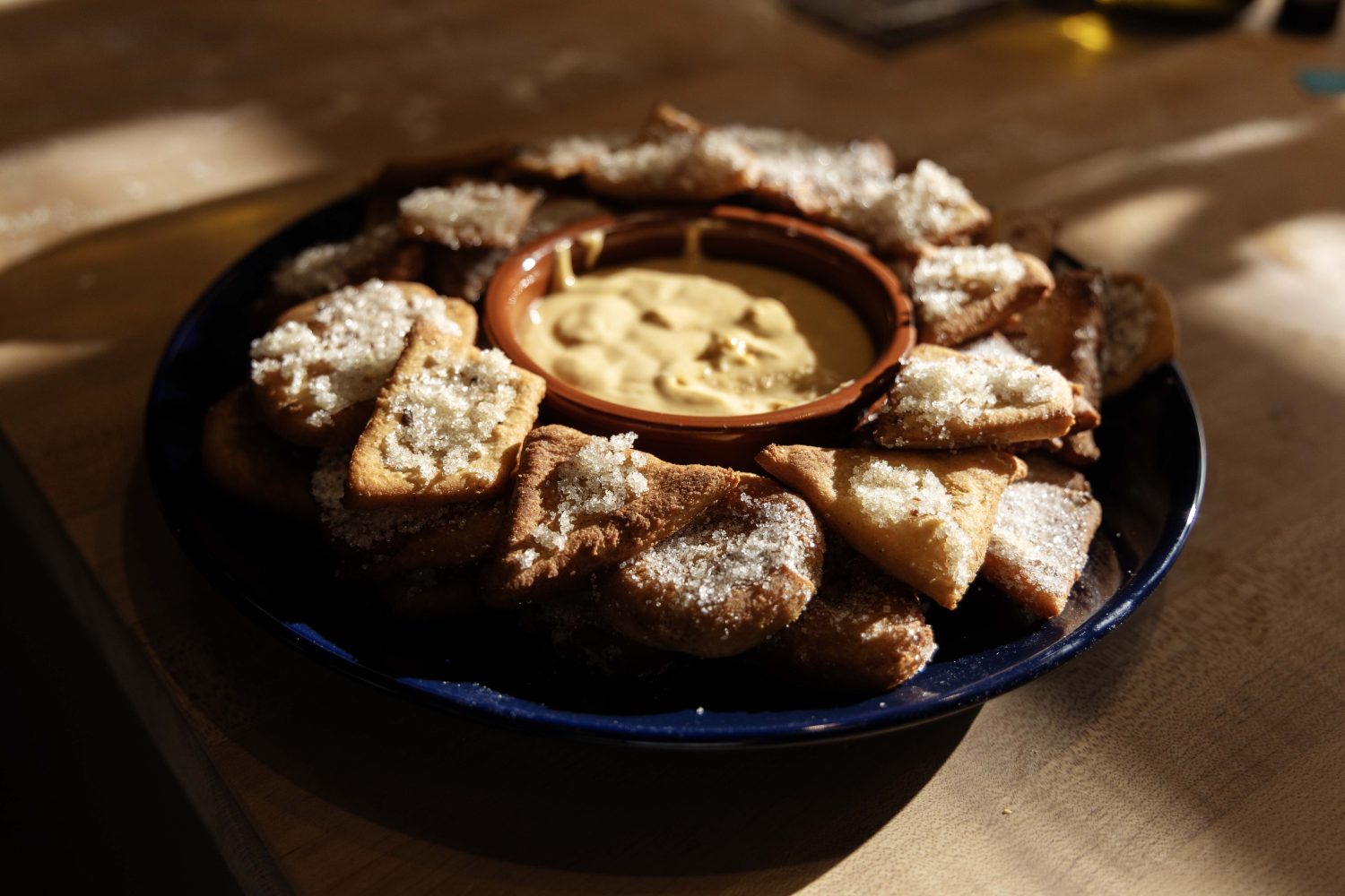The fried and sugared beignets souffles are piled on a plate with the sabayon dipping sauce