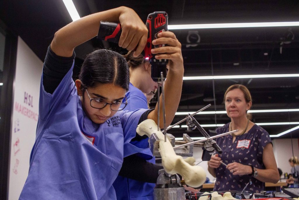 Students practice repairing a fractured femur with medal rods, on Saturday, Oct. 28, 2023. (Photo/Adria Carpenter)