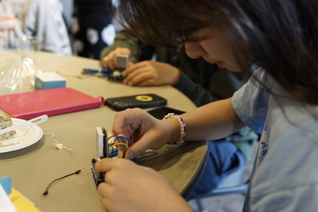 A teen wiring an LED matrix to a breadboard.