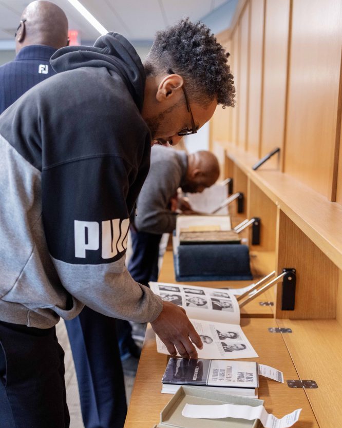 Michael Cribbs, outreach director at the YMCA of the Iowa Mississippi Valley in Davenport, examines materials from the Givens Collection of African American Literature, on Wednesday, April 17, 2024. (Photo/Adria Carpenter)