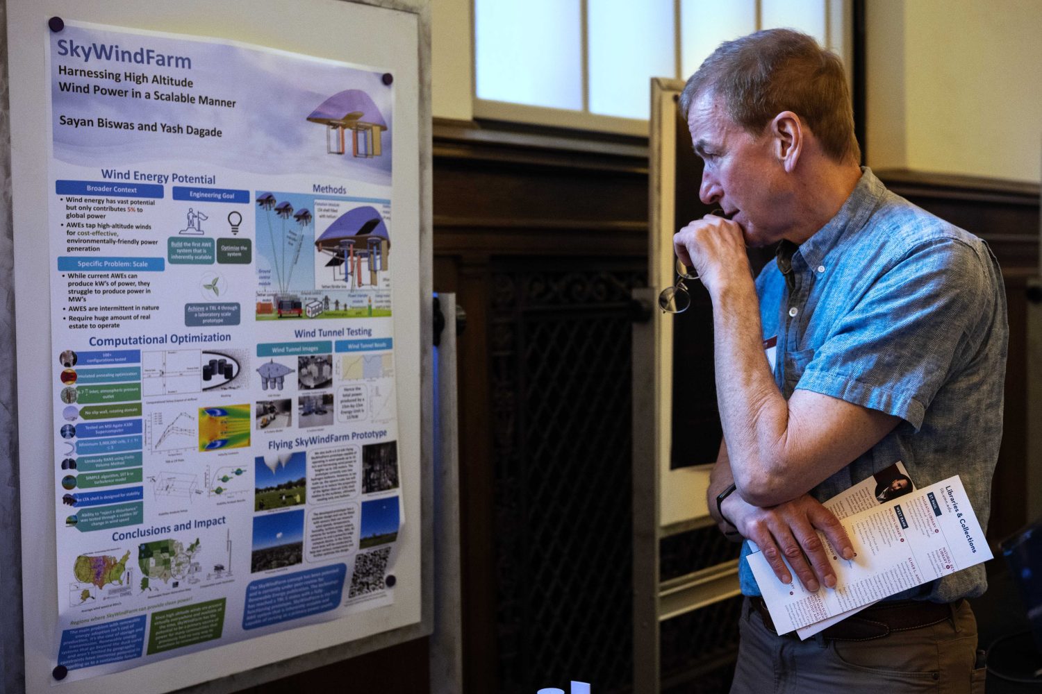 An attendee looks at the poster for SkyWindFarm, developed by Yash Dagade and Sayan Bishwa, during the Minimum Viable Product Challenge for Founder's Day at Walter Library on Wednesday, May 8, 2024. (Photo/Adria Carpenter)