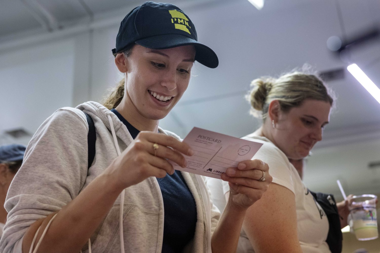An attendee grabs a postcard at the Andersen Horticultural Library's booth at the Minnesota State Fair on Thursday, August 29, 2024. (Photo/Adria Carpenter)