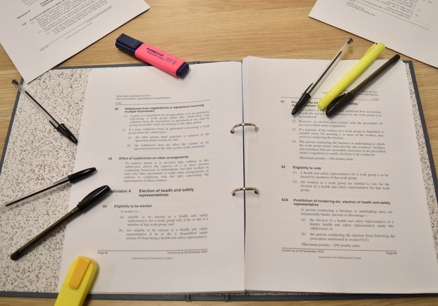 Binder with research articles and highlighters.