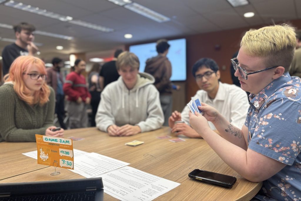 Four people playing a card game.