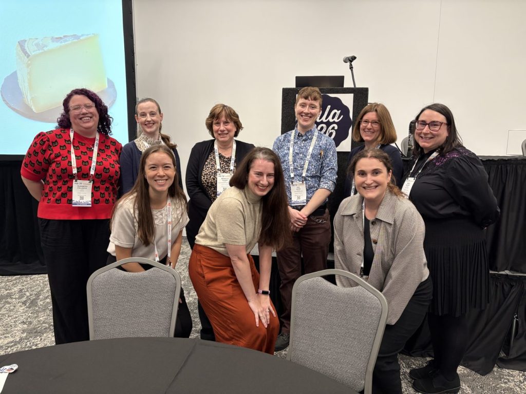 A group of nine librarians smile for the camera after presenting at the Medical Library Association's annual conference in 2026.