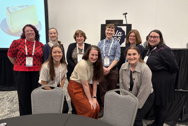 A group of nine librarians smile for the camera after presenting at the Medical Library Association's annual conference in 2026.