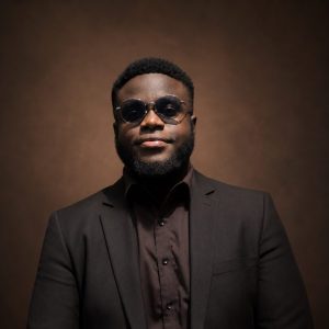 Portrait of a man in sunglasses and suit.